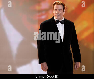 Noi attore John Travolta arriva sul palco per ricevere il premio per il miglior attore internazionale durante la 46th Golden fotocamera cerimonia di premiazione a Berlino, Germania, il 5 febbraio 2011. Il riconoscimento premia le preferite dal pubblico dal film, televisione, sport e media. Foto: Tobias Schwarz dpa/lbn Foto Stock