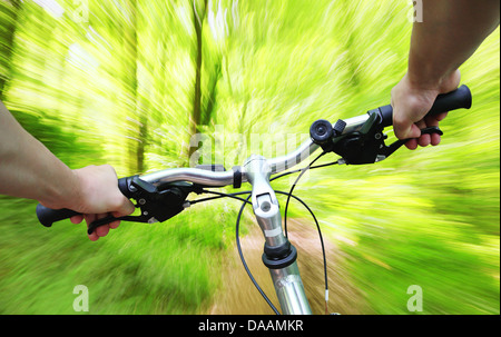 Equitazione bicicletta veloce attraverso la foresta Foto Stock