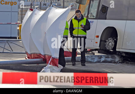 Investigatori della polizia fissare tracce dopo un incidente di autobus all'aeroporto di Francoforte sul Meno, Germania, 20 gennaio 2011. Il conducente ha perso il controllo del suo veicolo per motivi sconosciuti e ha spinto in una folla di passeggeri in piedi presso l'area dell'aeroporto. Un 24-anno-vecchia donna è morta e cinque persone sono state gravemente ferite. Foto: Boris Roessler Foto Stock