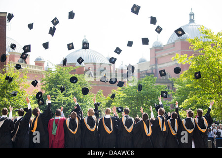 I laureati Buttare i tappi in aria alla Università di Birmingham, UK, dopo la cerimonia di laurea. Foto Stock