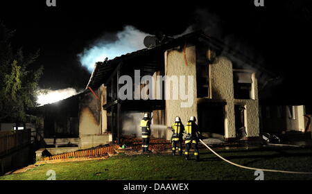 Feuerwehrleute löschen in der Nacht auf Dienstag (20.09.2011) in Grünwald bei München (Alta Baviera) brennenden das Haus des Fußballspielers Breno. Der Spieler des FC Bayern war nach Polizeiangaben allein zu Hause als das Feuer ausbrach und wurde mit leichten Verletzungen in eine Münchner Klinik gebracht. Foto: Tobias Hase dpa/lby Foto Stock