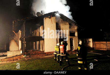 Feuerwehrleute löschen in der Nacht auf Dienstag (20.09.2011) in Grünwald bei München (Alta Baviera) brennenden das Haus des Fußballspielers Breno. Der Spieler des FC Bayern war nach Polizeiangaben allein zu Hause als das Feuer ausbrach und wurde mit leichten Verletzungen in eine Münchner Klinik gebracht. Foto: Tobias Hase dpa/lby Foto Stock