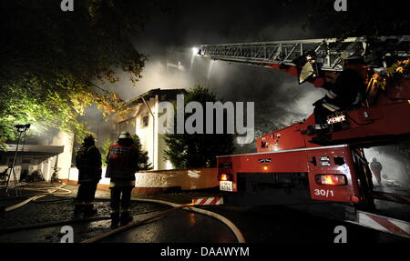 Feuerwehrleute löschen in der Nacht auf Dienstag (20.09.2011) in Grünwald bei München (Alta Baviera) brennenden das Haus des Fußballspielers Breno. Der Spieler des FC Bayern war nach Polizeiangaben allein zu Hause als das Feuer ausbrach und wurde mit leichten Verletzungen in eine Münchner Klinik gebracht. Foto: Tobias Hase dpa/lby Foto Stock