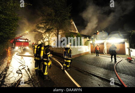 Feuerwehrleute löschen in der Nacht auf Dienstag (20.09.2011) in Grünwald bei München (Alta Baviera) brennenden das Haus des Fußballspielers Breno. Der Spieler des FC Bayern war nach Polizeiangaben allein zu Hause als das Feuer ausbrach und wurde mit leichten Verletzungen in eine Münchner Klinik gebracht. Foto: Tobias Hase dpa/lby Foto Stock