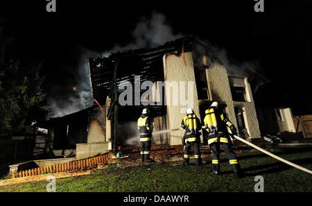 Feuerwehrleute löschen in der Nacht auf Dienstag (20.09.2011) in Grünwald bei München (Alta Baviera) brennenden das Haus des Fußballspielers Breno. Der Spieler des FC Bayern war nach Polizeiangaben allein zu Hause als das Feuer ausbrach und wurde mit leichten Verletzungen in eine Münchner Klinik gebracht. Foto: Tobias Hase dpa/lby Foto Stock