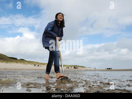 Corea del Sud studente, Dschi in ettari, è scavare per linee di business in tidelands presso il mare di Wadden Stazione di conservazione in Hoernum sull'isola di Sylt, Germania, 15 settembre 2011. Il 22-enne tedesco studi studente sta lavorando a volonteer alla stazione per due mesi. Foto: Christian Charisius Foto Stock