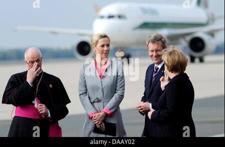 Il cancelliere tedesco Angela Merkel (C) talkes al Presidente tedesco Christian Wulff, sua moglie Bettina Wulff (M) e nunzio apostolico in Germania, Arcivescovo Jean-Claude Perisset (R) mentre il piano con Papa Benedetto XVI a bordo è arrivato presso l'aeroporto di Tegel a Berlino, Germania, 22 settembre 2011. Il capo della Chiesa Cattolica Romana si è recato in visita in Germania da 22-25 settembre 2011. Foto: Mau Foto Stock