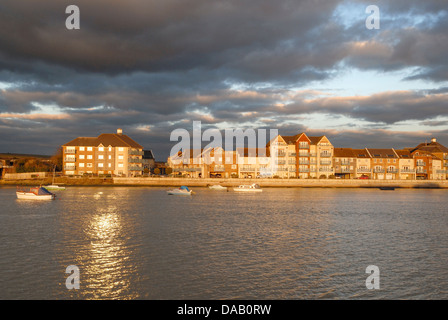 Nel tardo pomeriggio sun mette in evidenza uno sviluppo del waterfront homes accanto al fiume Adur nel West Sussex, in Inghilterra del sud. Foto Stock