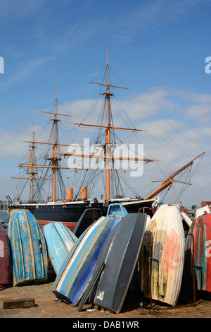 Sconvolto le piccole imbarcazioni con HMS Warrior dietro alla Historic Dockyard nel porto di Portsmouth, Hampshire, Inghilterra, Regno Unito. Foto Stock