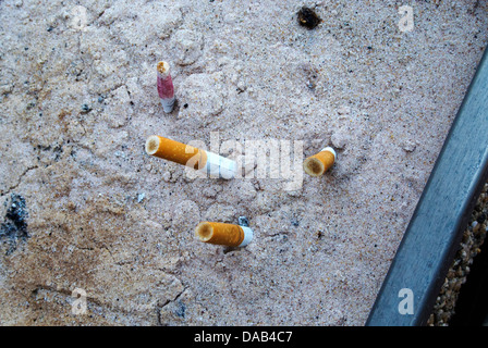 Mozziconi di sigaretta nella sabbia. Foto Stock