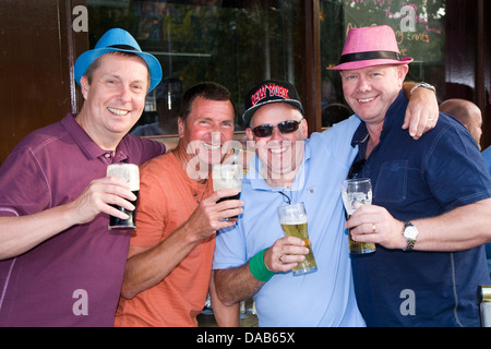 Amici in un party feste di addio al celibato e tostatura di bere una pinta / pinte di birra su di un weekend Stag a Dublino, Eire / Irlanda. Foto Stock