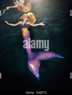 Fantasy donna vera sirena mito dea del mare con coda dorata seduta al  tramonto su rocce. Oro conchiglie corona gioielli perle. Sirena accesa Foto  stock - Alamy