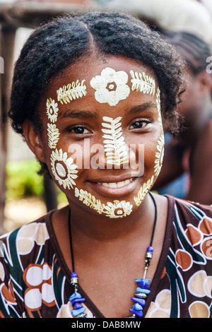 Sakalava giovane donna con il suo tradizionale maschera di bellezza a Nosy Be, Madagascar Foto Stock