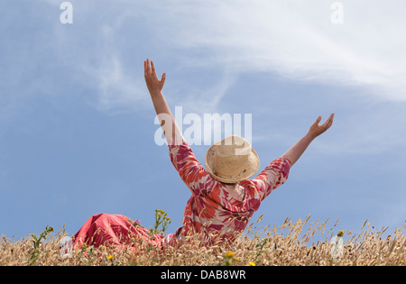 Donna con le mani alzate verso il cielo Foto Stock