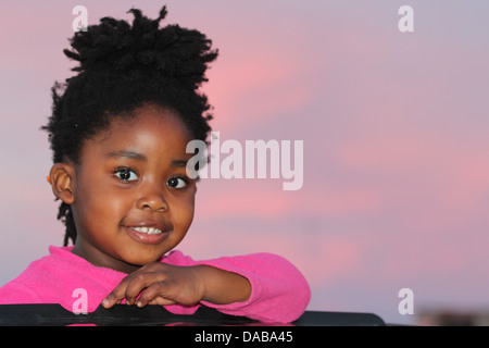 Baby girl se un tettuccio apribile al tramonto Foto Stock