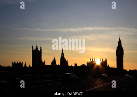 Il Palazzo di Westminster e il Big Ben stagliano contro il sole di setting, come visto dal Westminster Bridge Foto Stock