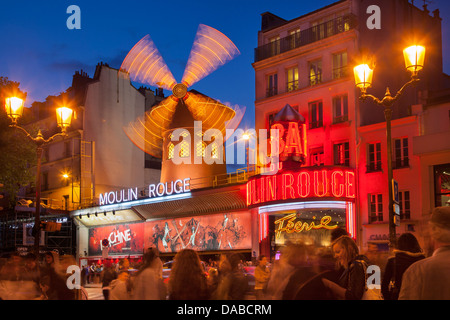 I turisti al di sotto del Moulin Rouge (1889), famosa in tutto il mondo Cabaret, Pigalle, Paris Francia Foto Stock