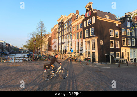 Ciclista attraversando un ponte sul canale Keizersgracht, Amsterdam, Paesi Bassi, Europa Foto Stock