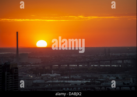 Un tramonto di masterizzazione termina una giornata calda a Melbourne la capitale della stato australiano di Victoria. Foto Stock