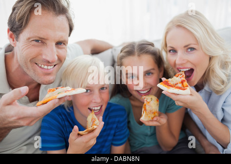 Famiglia sorridente mangiare la pizza Foto Stock