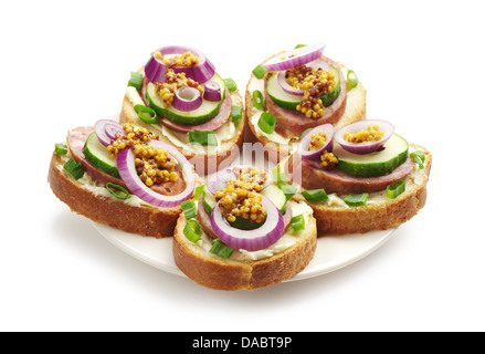 Panini con salsiccia e verdi su una piastra bianca Foto Stock