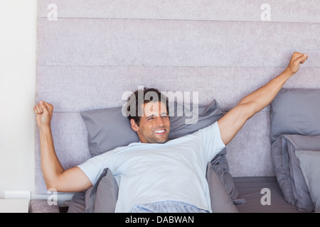 Uomo bello svegliarsi e stretching Foto Stock
