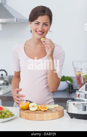 Donna incinta di mangiare un'uva Foto Stock