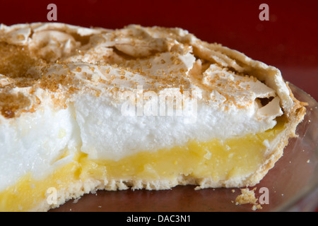 Home reso Lemon Meringue Pie in recipiente di vetro rosso sul piano di lavoro Foto Stock