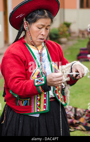 Tradizionalmente vestito rosso vestito in costume maglione abbigliamento Inca donna Inca spin la filatura della lana Chincheros tessili, Perù. Foto Stock