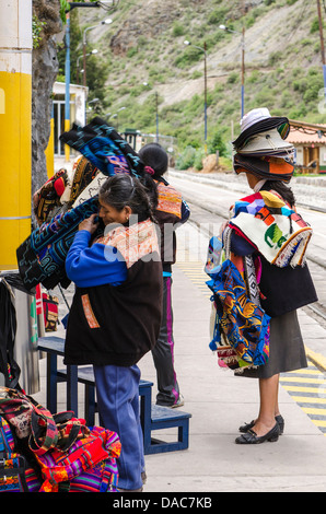 I venditori di souvenir in attesa per i treni auto carrello al Ollanta stazione dei treni di Ollantaytambo, Valle Sacra, Perù. Foto Stock