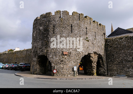 Auto parcheggiate a fianco della cinta medievale di Tenby fino al vecchio West Gate, ora noto come i cinque archi barbican gatehouse. Foto Stock