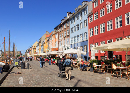 Lungomare pedonale strada con caffè all'aperto e gli edifici colorati in Copenhagen Nyhavn Zelanda Danimarca Scandinavia Foto Stock