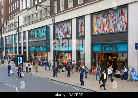 Marciapiede occupato con gli acquirenti fuori Primark, abbigliamento veloce, negozi, negozi, negozi, negozi, negozi, negozi, finestre, Oxford Street West End, Londra, Inghilterra Foto Stock