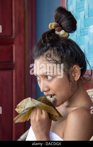 Giovane donna mangiare riso cotto a vapore in foglia di banano stile Lao Foto Stock