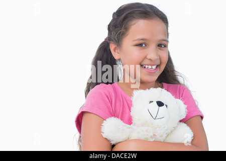 Bambina mentre tiene il suo orsacchiotto Foto Stock