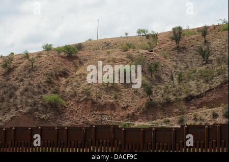 Luglio 10, 2013 - Nogales, Arizona, Stati Uniti - Due scout, visibile solo al di sopra di un pneumatico scartato, guardare la U.S. Pattuglia di Confine agenti e delle attività dal Messico vicino a Nogales, in Arizona (Credito Immagine: © sarà Seberger/ZUMAPRESS.com) Foto Stock