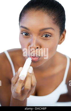Giovane donna mettendo balsamo per labbra sulle labbra Foto Stock