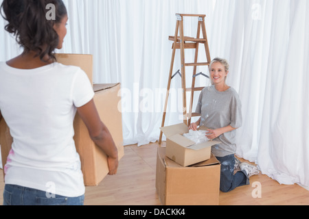 Giovani amici disimballaggio nella loro nuova casa Foto Stock