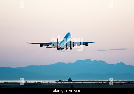 Un British Airways Boeing 747-400 wide-body jumbo jet aereo di linea si discosta al crepuscolo e dall'Aeroporto Internazionale di Vancouver. Foto Stock