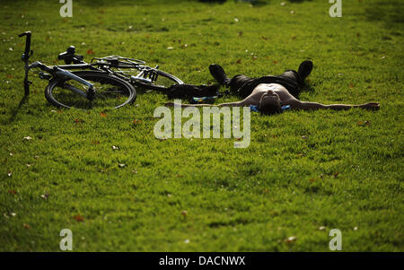 Un cylcists gode del sole su un campo sul Lago Alster Amburgo, Germania, 28 settembre 2011. Foto: Christian Charisius Foto Stock
