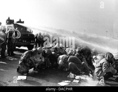 (FILE) un archivio foto datata 26 febbraio 1981 mostra la polizia cercando di rompere una manifestazione contro la centrale nucleare con acqua canonici di Brokdorf, Germania. Venticinque anni fa, il reattore nucleare di Brokdorf, che continuerà a funzionare fino al 2021, ha ricevuto il suo permanente le operazioni di autorizzazione e non vi sono state violente proteste contro la sua costruzione. Foto: Wulf Pfeiffer Foto Stock