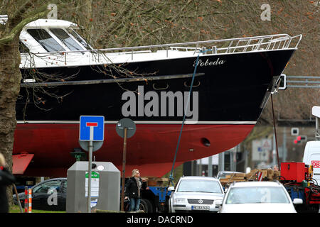 Mit einem Tieflader wird am Dienstag (13.12.2011) die 20 Meter grosse niederländische Stahlyacht "Pobeda" zur Düsseldorfer Messe gefahren. Das Schiff ist eines der Ersten Ausstellungsstücke für die Wassersportmesse 'boot 2012', die vom 21. bis 29. Januar 2012 in allen Düsseldorfer Messehallen stattfindet. Foto: Roland Weihrauch dpa/lnw Foto Stock