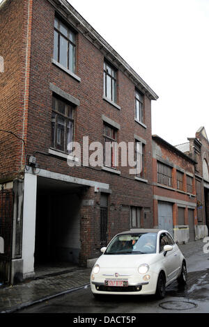 Una vettura passa la casa dove la polizia ha trovato il corpo di una donna nel garage di un bandito di Liegi, in Belgio, il 14 dicembre 2011. Il pistolero ucciso cinque persone, tra cui lo stesso, e feriti oltre 120 in un attacco con granate e spari nel centro di Liegi su Martedì, 13 dicembre. Foto: Marius Becker dpa +++(c) dpa - Bildfunk+++ Foto Stock