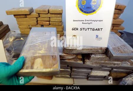 Una mano che contiene un pacchetto di cocaina appartenente ad un farmaco trovare di 130 kg allo stato di polizia criminale di Stoccarda, Germania, 20 dicembre 2011. La polizia e l'ufficio doganale busted attiva a livello globale di droga colombiano anello del concessionario. Circa 130 kg cocain dal Sud America del valore di diversi milioni di euro sono stati confiscati a Reutlingen. Foto: BERND WEISSBROD Foto Stock