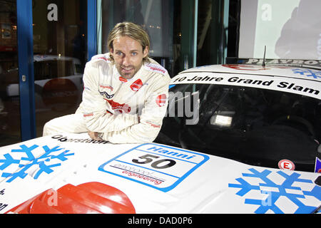 Ex tedesco ponticello sci Sven Hannawald pone con una vettura da gara del GT-Masters Series durante una conferenza stampa ha avviato il decimo anniversario del suo quattro-tempo vittoria al Torneo delle quattro colline nel 2001 a Oberstdorf in Germania, 28 dicembre 2011. Hannawald è il solo atleta, che ha vinto tutti e quattro i campionati del Torneo delle quattro colline e raggiunto un cosiddetto Grand Slam. Egli non è Foto Stock