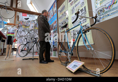 Un visitatore osserva un grafico accanto alla bicicletta della marca Diamant, con cui Bernd Drogan ha vinto i Campionati del Mondo 1979 in Valkenburg, presso il museo del ciclismo in Wuensdorf, Germania, 29 dicembre 2011. Vecchie e nuove biciclette, maglie storiche e molti solleciti della storia di professionali nazionali ed internazionali gare di bicicletta sono disponibili presso il museo. Foto: Bernd Sett Foto Stock