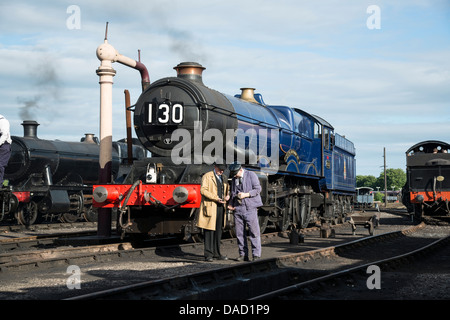 Driver caposquadra e controllare il tempo in piedi nella parte anteriore della storica locomotiva a vapore 6023 re Edoardo II a Didcot Railway Centre. Foto Stock