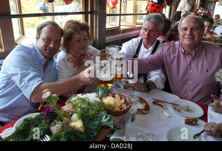 Il direttore sportivo della Bundesliga club FC Bayern Monaco, Christian Nerlinger (L), capo allenatore della squadra Jupp Heynckes (2-R) e sua moglie Iris, nonché presidente del club di Uli Joeness spiraglio bicchieri al della Kaefer tenda durante la visita ufficiale del club al Oktoberfest 2011 a Monaco di Baviera, Germania, 02 ottobre 2011. Il 178mo Oktoberfest attrae visitatori da tutto il mondo Foto Stock