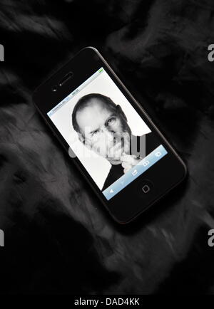 Illustrazione - il ritratto del co-fondatore di Apple, Steve Jobs, è presentato sulla pagina di copertina di "apple.com' e mostrato sul display di un Apple iPhone 4 in Francoforte sul Meno, Germania, 06 ottobre 2011. Co-fondatore e lunga testa di Apple è morto il 05 ottobre 2011 all'età di 56 in California. I lavori hanno dovuto combattere contro il cancro pancreatico per molti anni. Foto: Arne Dedert Foto Stock