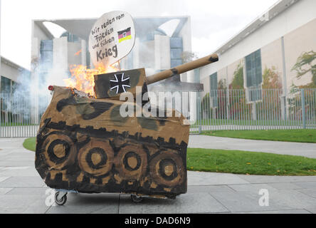 Manifestanti masterizzare un finto serbatoio nella parte anteriore della cancelleria durante una dimostrazione contro la distribuzione della Bundeswehr (tedesco forze armate) in Afghanistan, Berlino, 08 ottobre 2011. I manifestanti richiedono l'immediato e incondizionato ritiro delle truppe. Essi assemblati a Potsdamer Platz e reso il loro cammino verso la Cancelleria tedesca. L'international Afghanistan missi Foto Stock